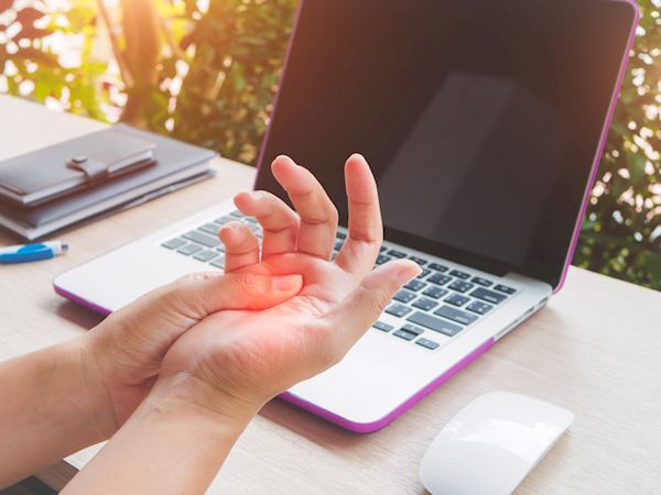 mano dolorante davanti il computer per sindrome tunnel carpale